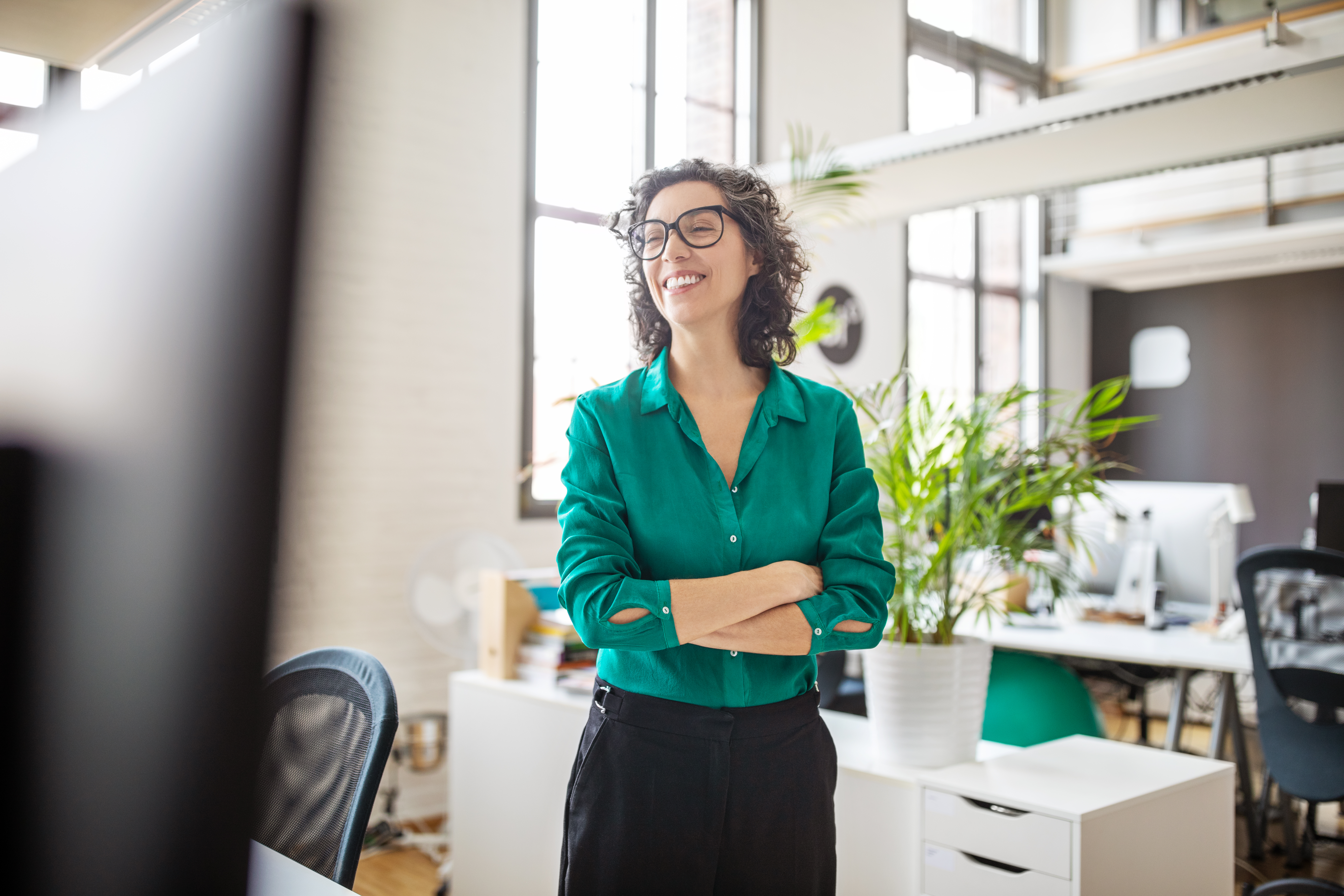 Une femme souriante dans les bureaux d'une entreprise