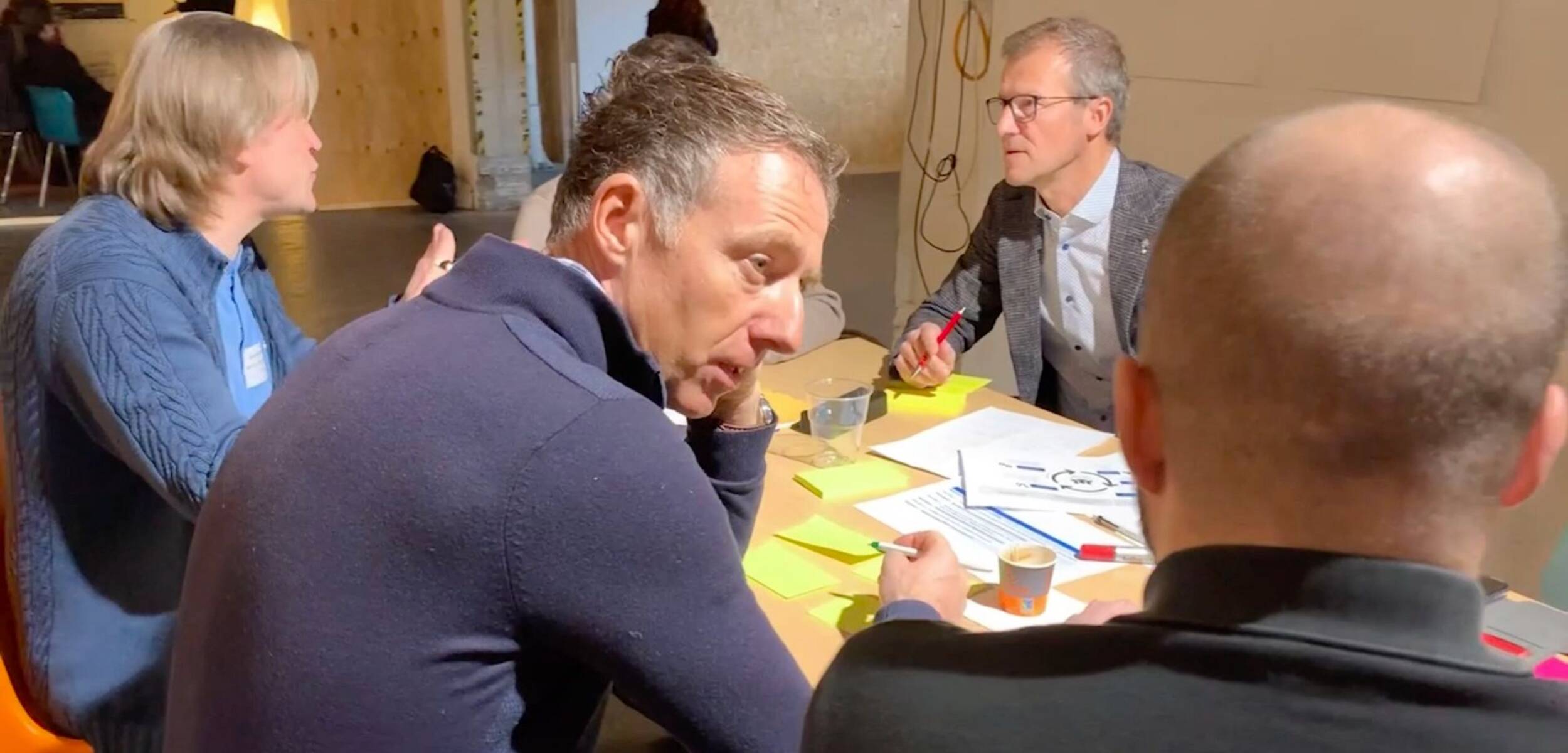 Un groupe autour d'une table qui travaille avec des post-it